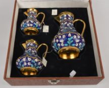 A graduated set of three Soviet Russian silver coloured gilt and enamel baluster jugs and covers,