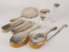 A matched silver dressing table set by Henry Matthews, Birmingham 1913 and 1915, four brushes and a