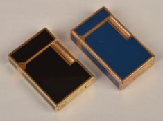 Two cigarette lighters by Dupont, one a black enamel and one blue, both with rolling cylinder side