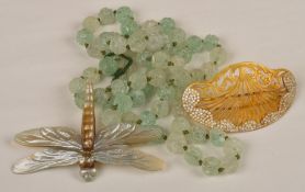 A small collection of costume jewellery, including a carved green bead necklace, a shell dragon fly