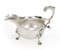 A George II silver oval sauce boat, maker`s mark indistinct, London 1749, with a leaf-capped flying