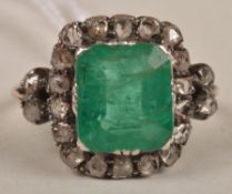 A Victorian emerald and diamond cluster ring, the central rub over set emerald with a surround of