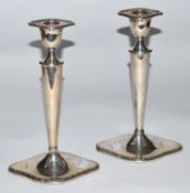 A matched pair of Edwardian silver candlesticks by William Hutton & Sons Ltd., London 1906 and