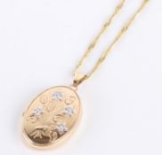 * A 9 carat two colour gold locket, of oval shape with floral decoration, 3cm long including bale,