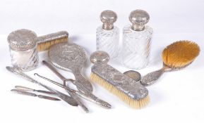 A French silver coloured mounted dressing table set, embossed with shells, foliate sprays and