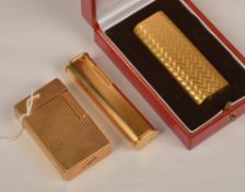 Cartier: a lighter with engraved decoration, signed and numbered, cased, and a Dunhill lighter with