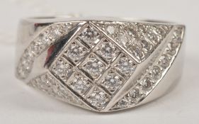 A diamond band ring, the stepped head pave set with brilliant cut diamonds, stamped `750`, finger