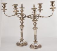 A pair of eleectro-plated twin branch candelabra, with flame finials, the circular sconces with