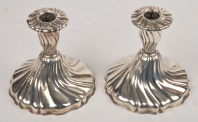 A pair of silver coloured dwarf candlesticks, stamped 925, with wrythen decoration, 11.5cm high, 3.