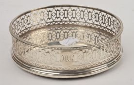 A Georgian silver coaster by Robert Hennell, with a beaded border, pierced gallery and wooden base,