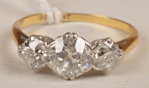 A three stone diamond ring, claw set with an old brilliant-cut diamond, estimated to weigh