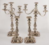 A pair of twin branch three light candelabra, the shaped square sconces chased with foliate