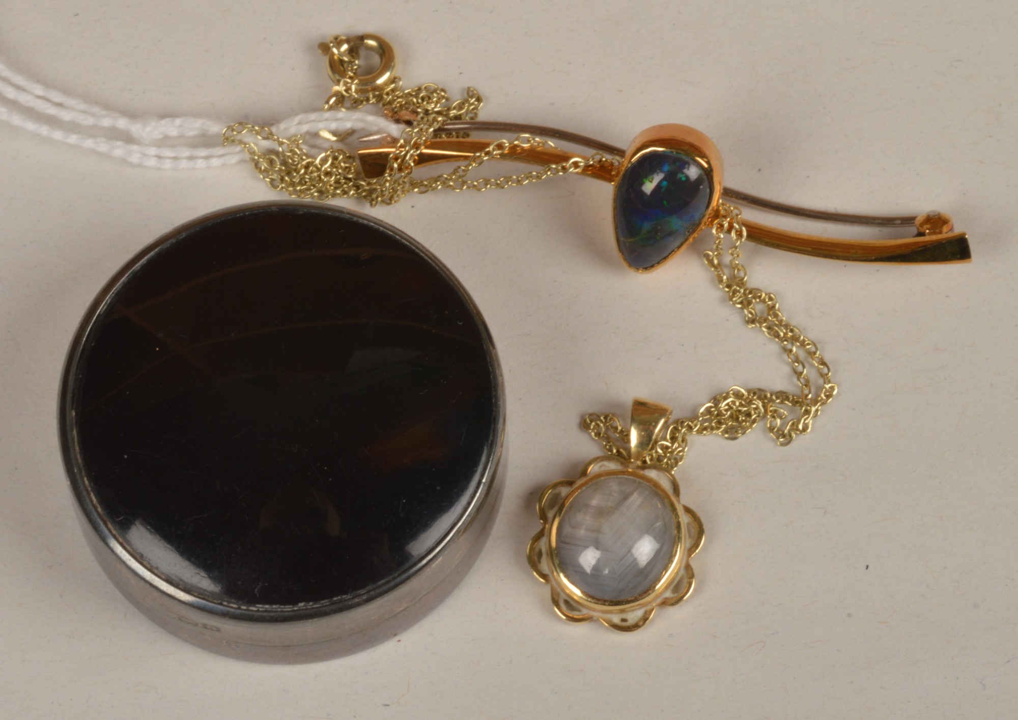 An 18 carat gold star sapphire pendant on a fine link chain, the cabochon sapphire collet set with
