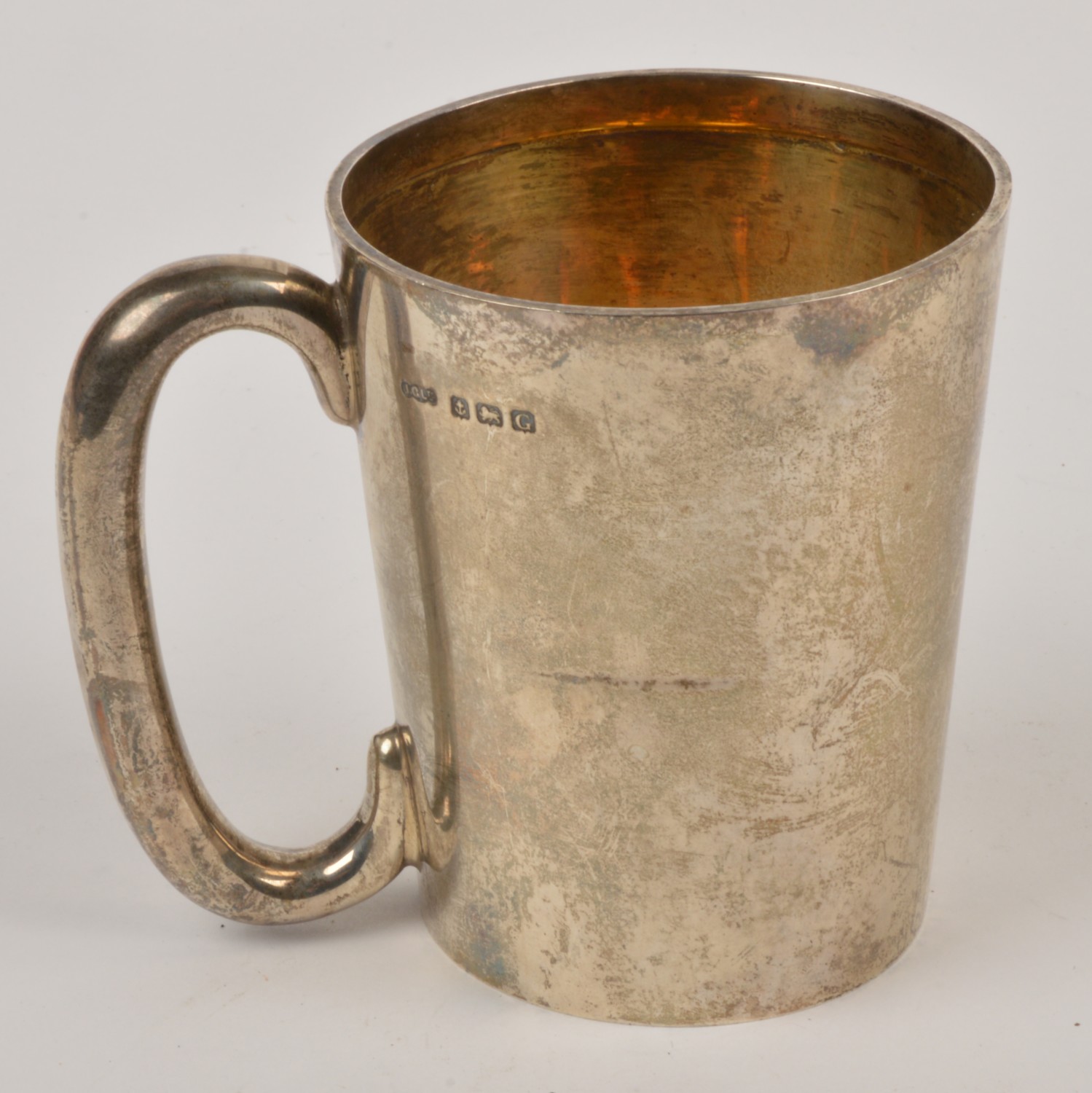 A silver slightly tapering mug by Joseph Gloster Ltd., Birmingham 1931, with a `c` shaped handle,