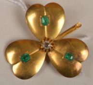An emerald and diamond clover leaf brooch, each leaf set with an emerald with a round cut diamond