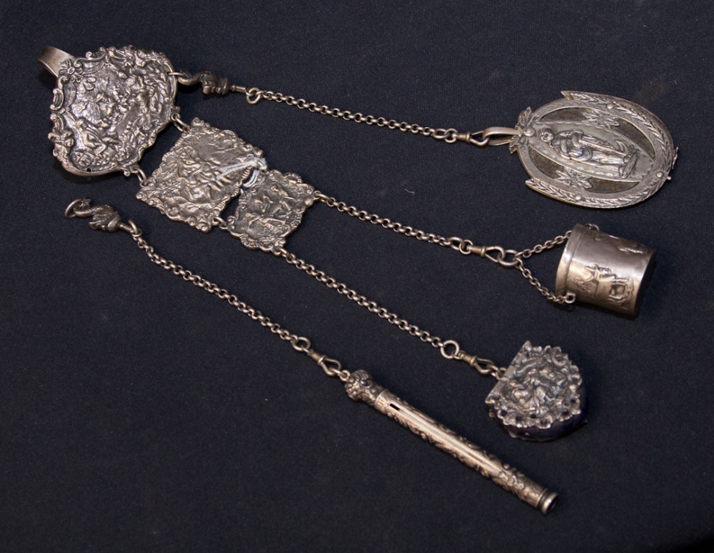 A white metal continental chatelaine, with aide memoir, pencil, pin cushion and thimble case