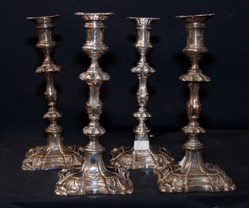 A Set of Four Mid 19th Century Sheffield Plate Candlesticks, in the George II style, scrollwork to