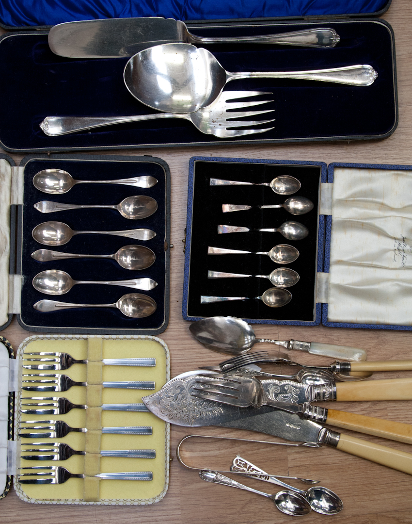 A collection of silver and silver plate flatware, including George III bright cut sugar tongs with