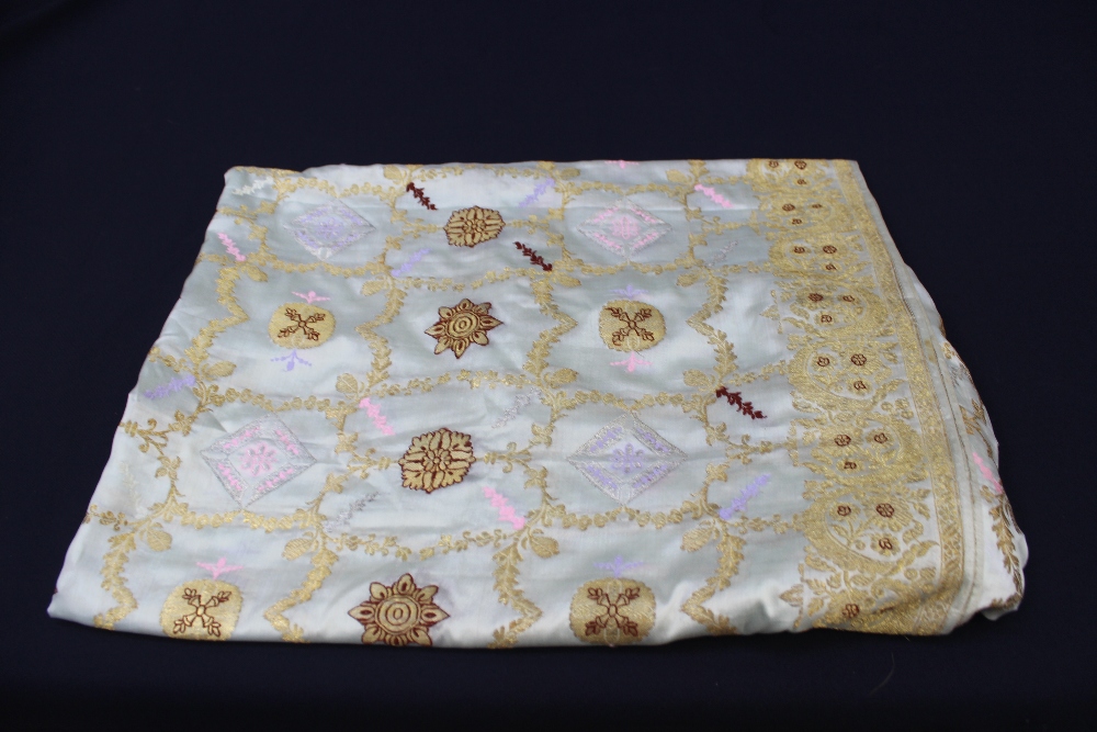 A 1920s embroidered panel on a light blue silk background and covered in gold embellishment,