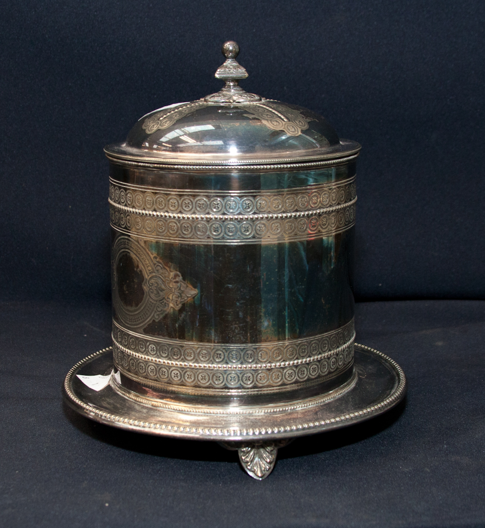 An Edwardian silver plated biscuit barrel with hinged lid and fixed tray base (wine cooler)