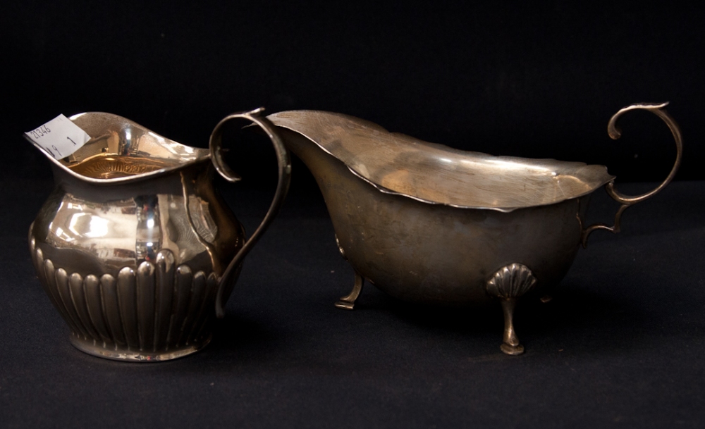 A silver sauce boat, Birmingham 1933, with a silver cream jug, Birmingham 1907, weighing a total