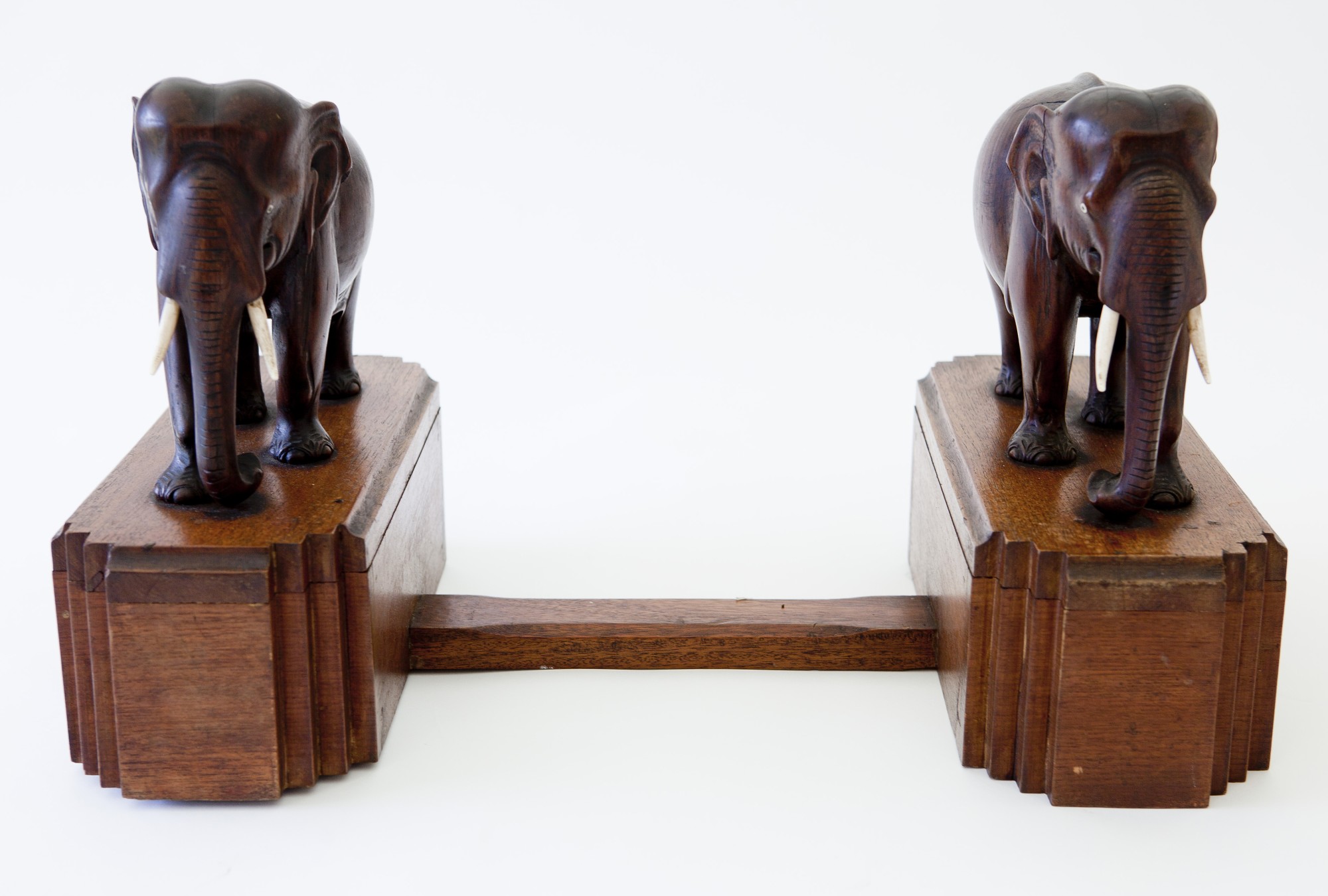 A pair of Art Deco style bookends, the two carved hardwood elephants standing on geometric bases,