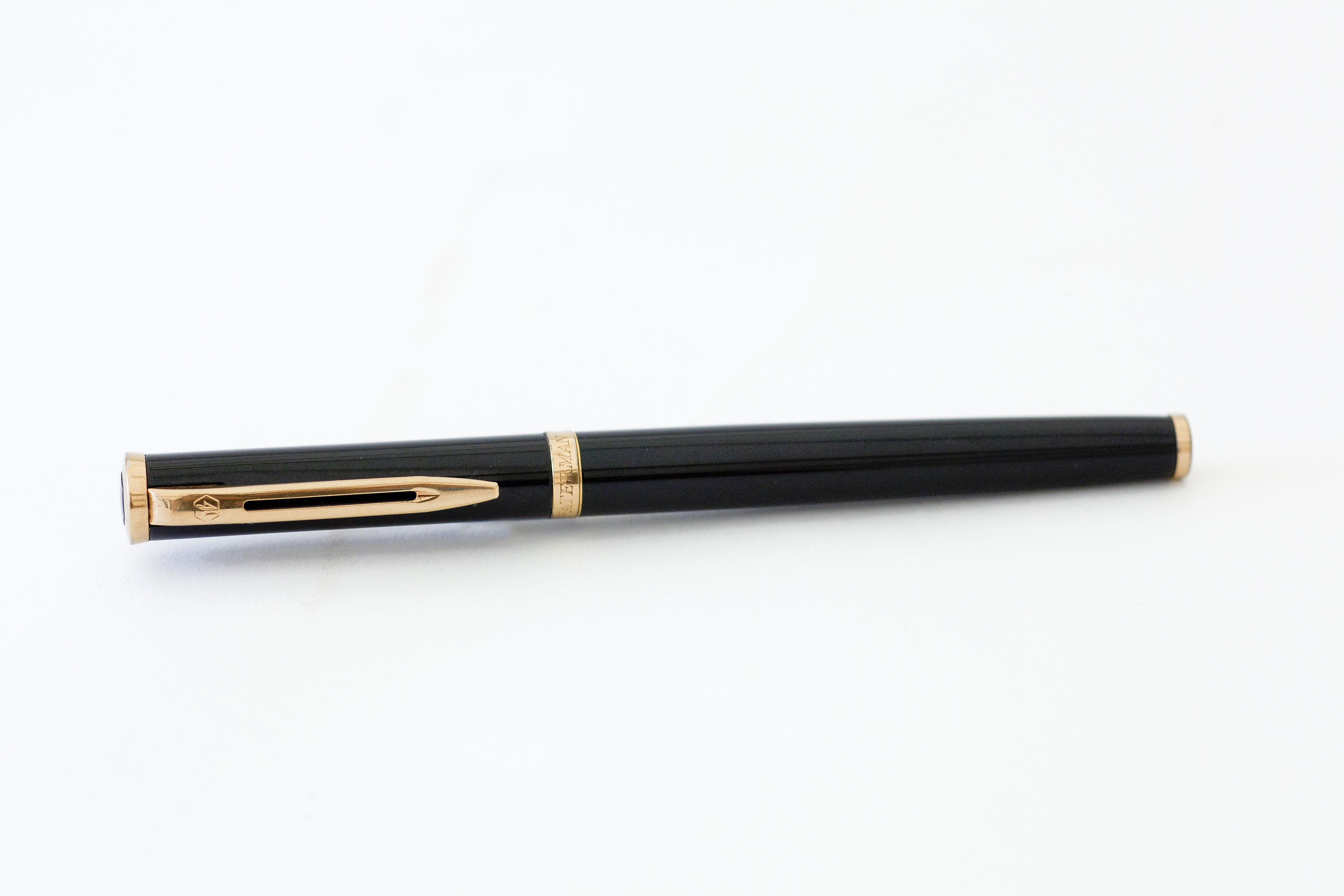 A Waterman's fountain pen, black body with yellow metal mounts, the band inscribed Waterman