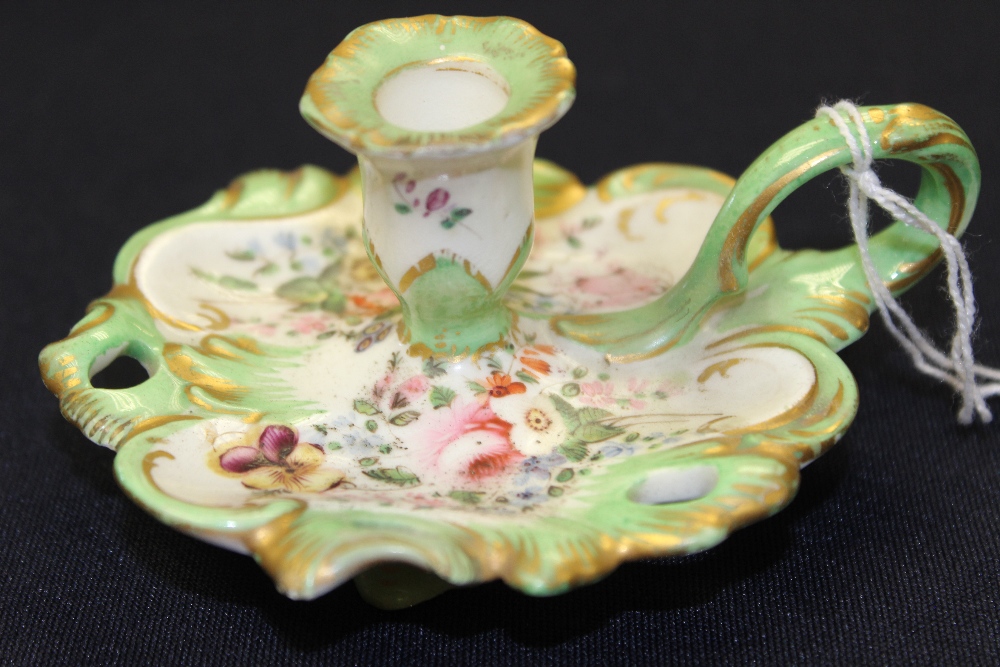 A 19th century English porcelain chamber stick, painted with flowers, green border highlighted in