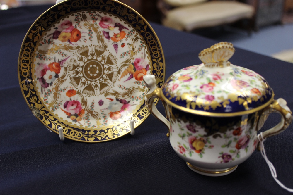 An English porcelain twin-handled chocolate pot and cover, painted with flowers, cobalt blue border,