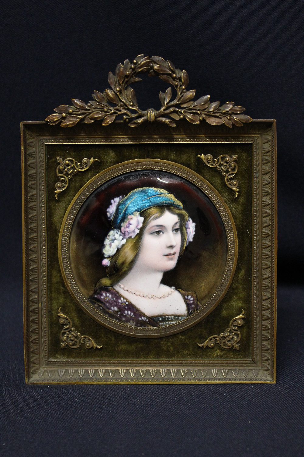 A late 19th century Limoges enamel of a Pre Raphaelite lady, circa 1890, of circular convex outline,