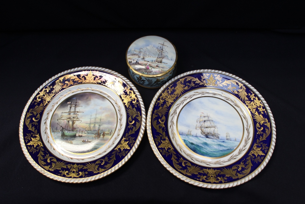 A pair of Lynton porcelain plates, painted with ships, cobalt blue border, signed S Nowaki, a Lynton