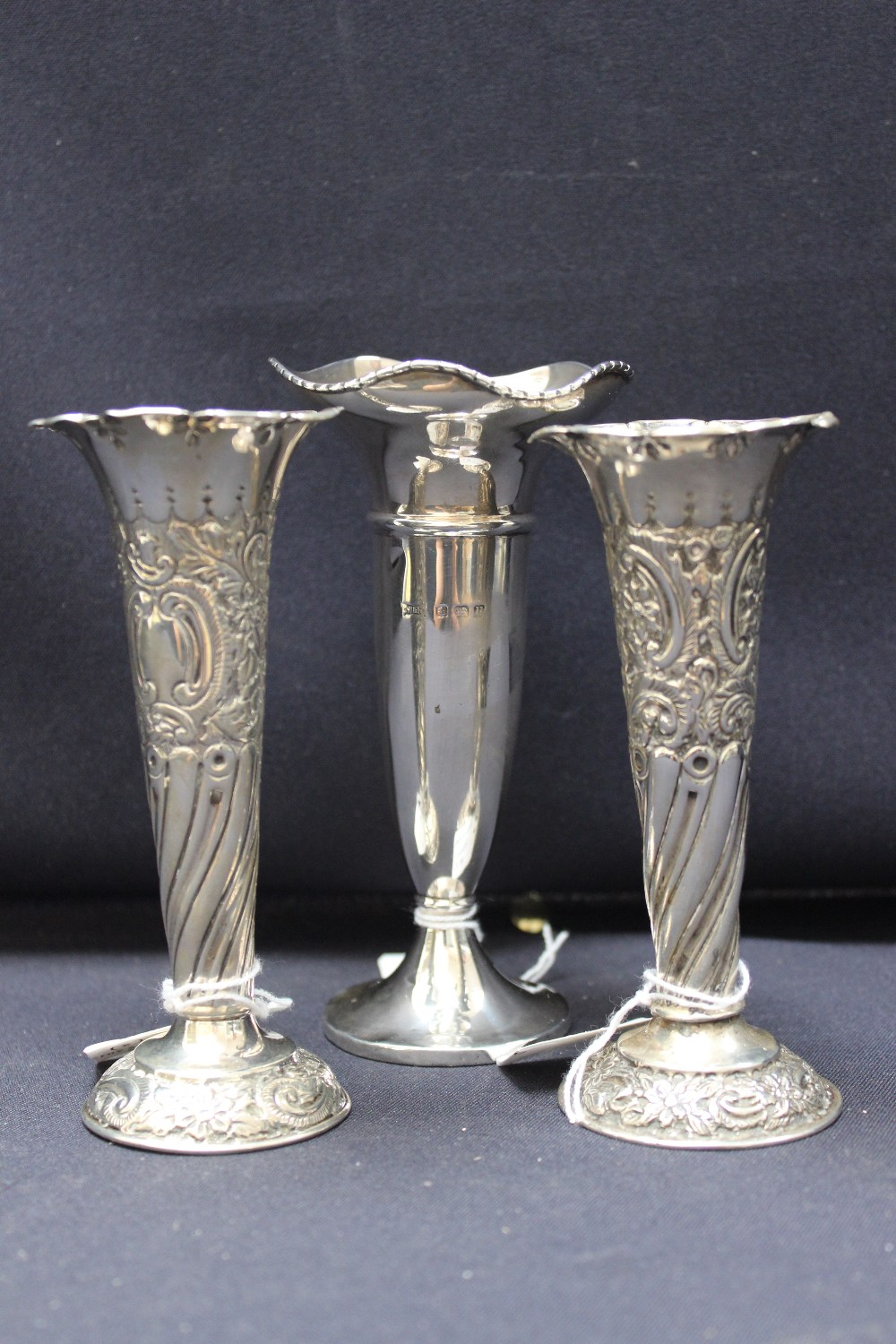 Three hall marked silver vases, filled. (3)