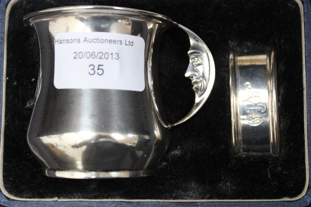 A silver Christening set, comprising mug with crescent moon handle and a napkin ring, boxed