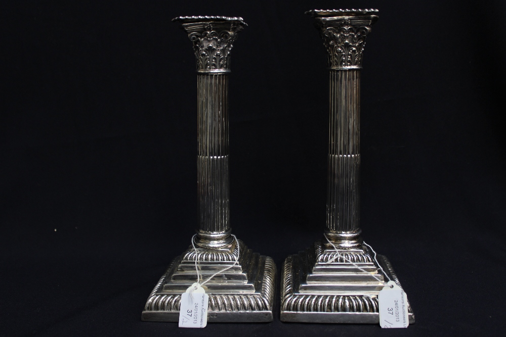 A pair of Victorian silver candlesticks on stepped square bases, with gadroon border, Corinthian