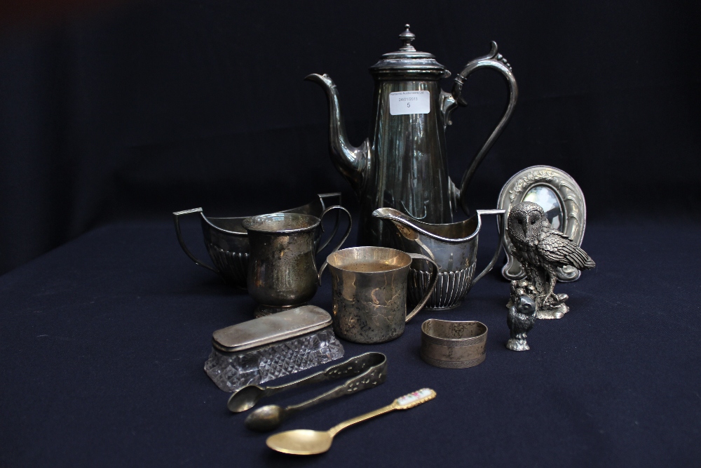 A sterling silver model of an owl, silver napkin ring, EPNS frame, sugar bowl, cream jug, silver-