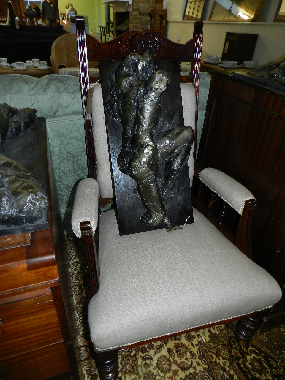 A mid Victorian carved mahogany smokers chair, having upholstered arms and supported on turned