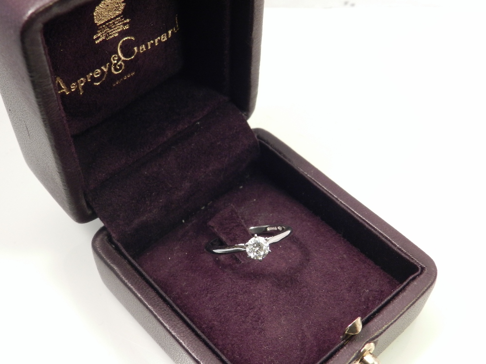 Garrards, London. A platinum mounted solitaire diamond dress ring.