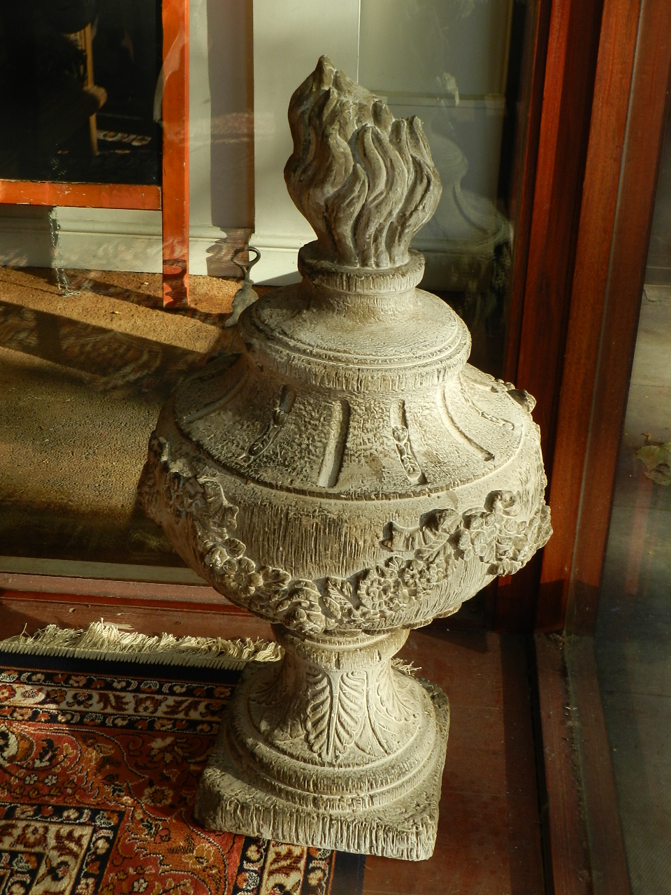 A pair of ceramic finials, decorated with swags and leaves.