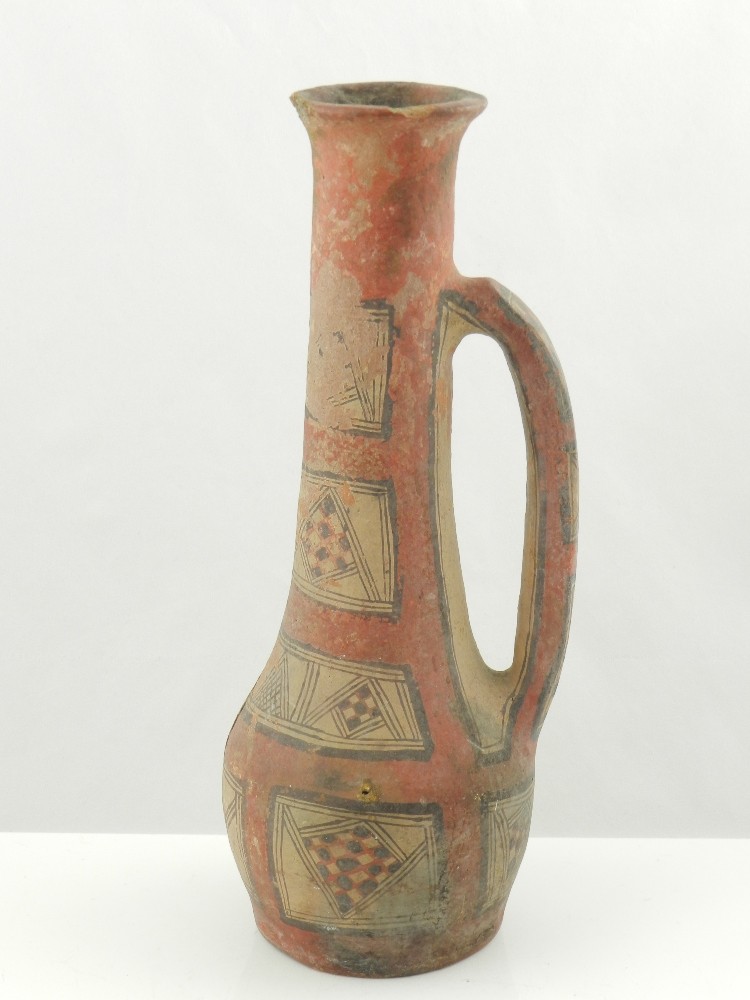 An early pre-Columbian style terracotta ewer, painted with geometric panels. H. 32 cm.