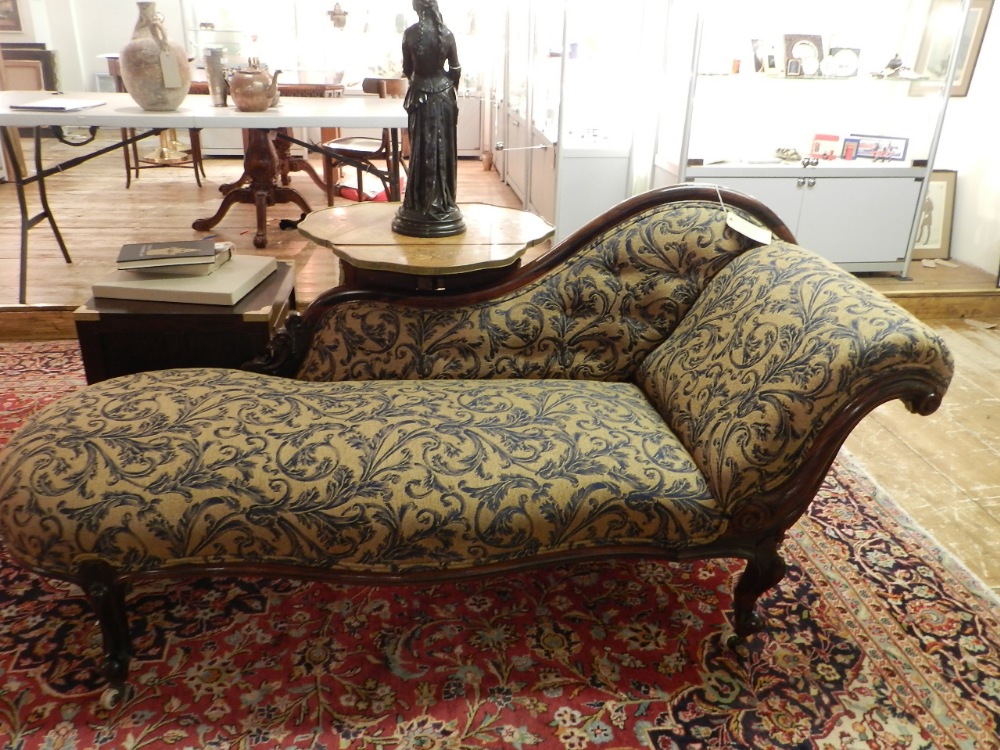 An early Victorian simulated rosewood scroll end chaise longue, raised on cabriole legs and casters.