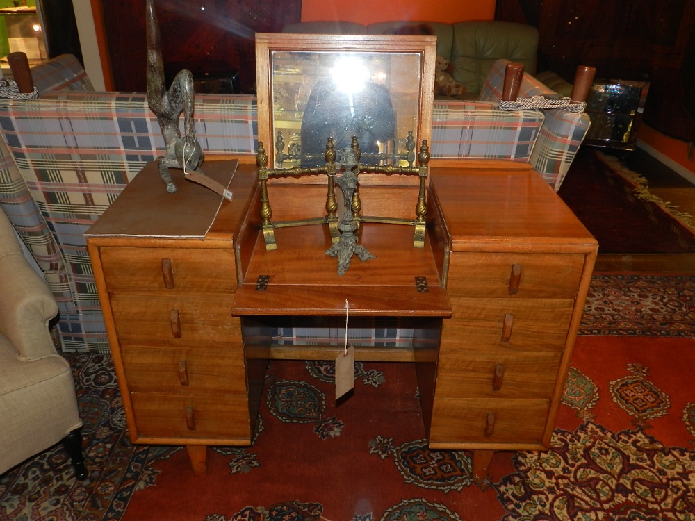 A 1960's teak dressing table/desk, having rising mirror flanked by four drawers on either side.