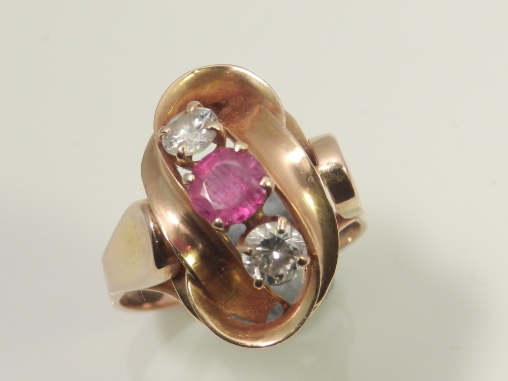 A ladies 18ct gold dress ring, having central ruby flanked by two diamonds.