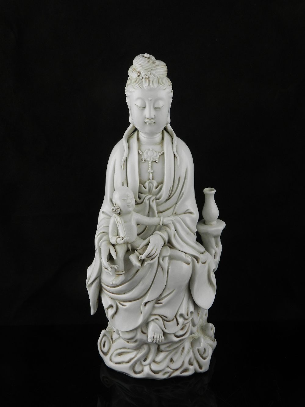 A Chinese blanc de chine porcelain model of Guan Yin with child.