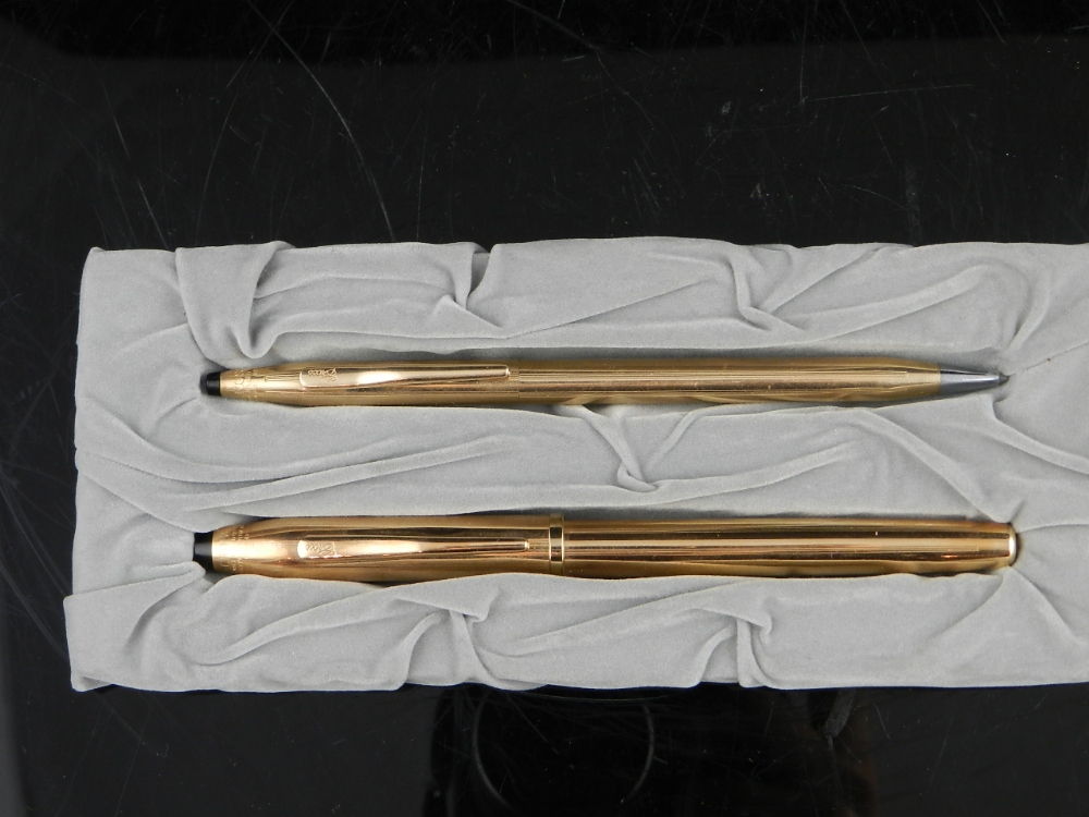 A pair of gold plated Cross pens, one ballpoint, the other an 18ct nib fountain pen.