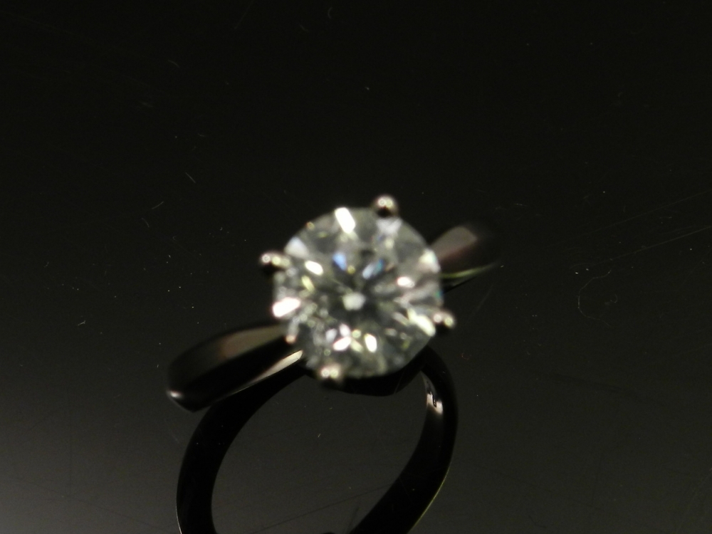 A white metal set solitaire diamond ring, the brilliant cut stone of approx. 2cts, the shank