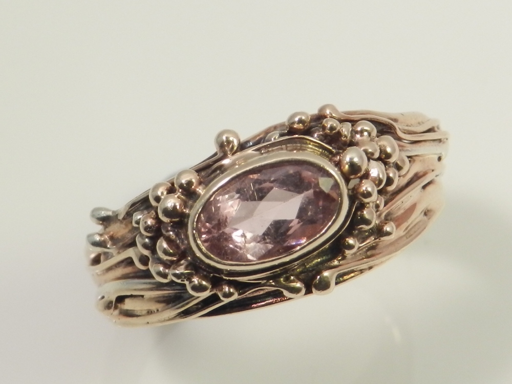 A 9ct gold ladies dress ring, set with faceted pink tourmaline in the Arts and Crafts style.