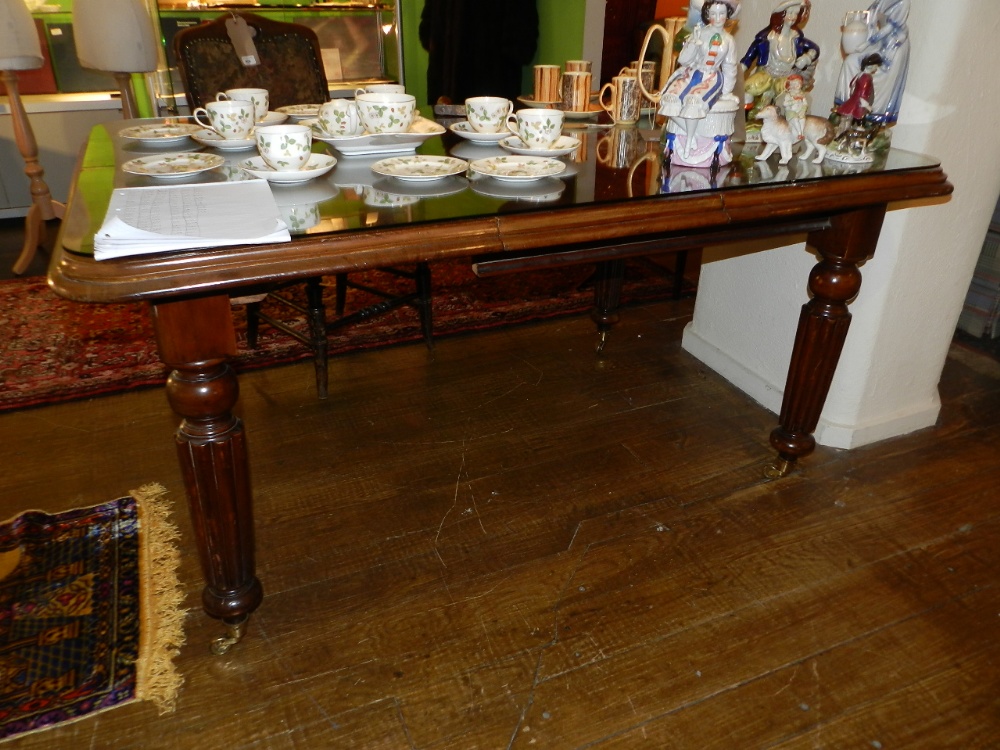 A Victorian mahogany dining table of rounded rectangular form, with a single leaf, on four