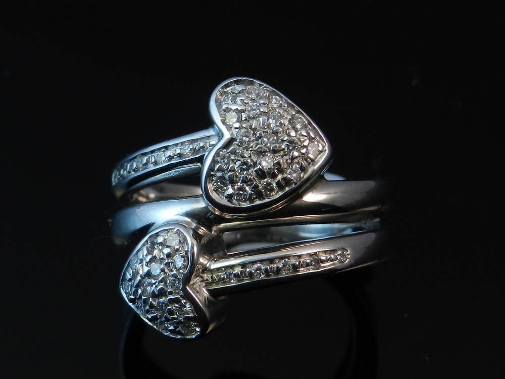 A white metal and diamond set cross-over ring, pave set and marked 750.