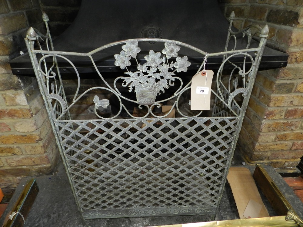 A cast iron three fold fender with pierced trellis pattern, scrollwork and embossed flowers.