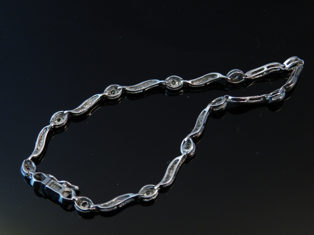 A white metal and diamond set bracelet, stamped 750.